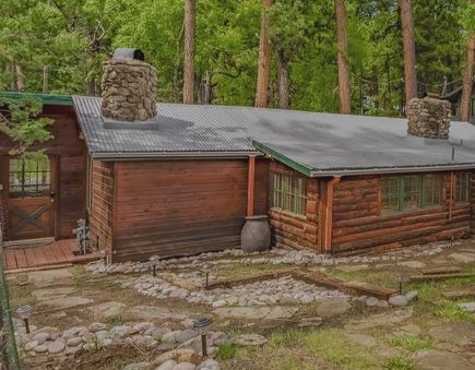 A log cabin with multiple stone chimneys