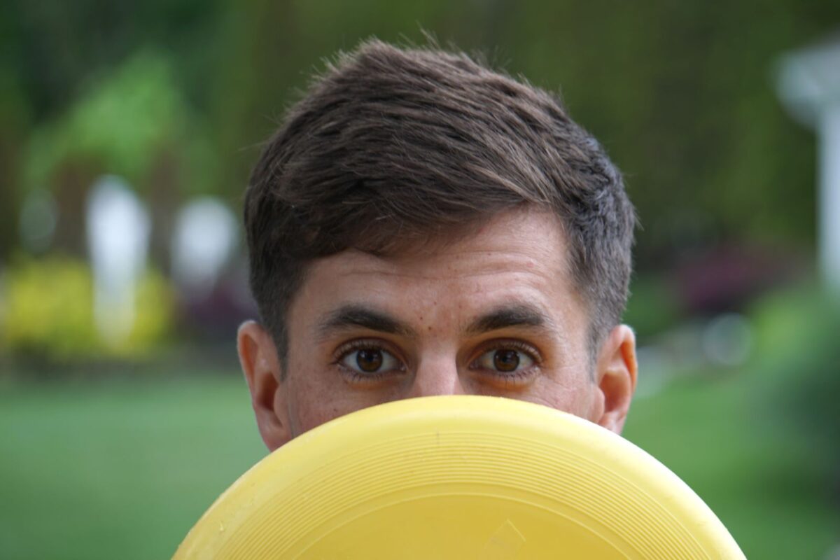 man holding a frisbee in front of his face